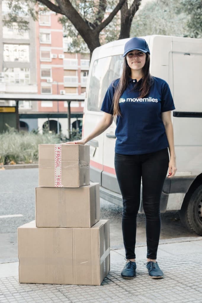 MoveMiles movers at work - team in green shirts carrying boxes
