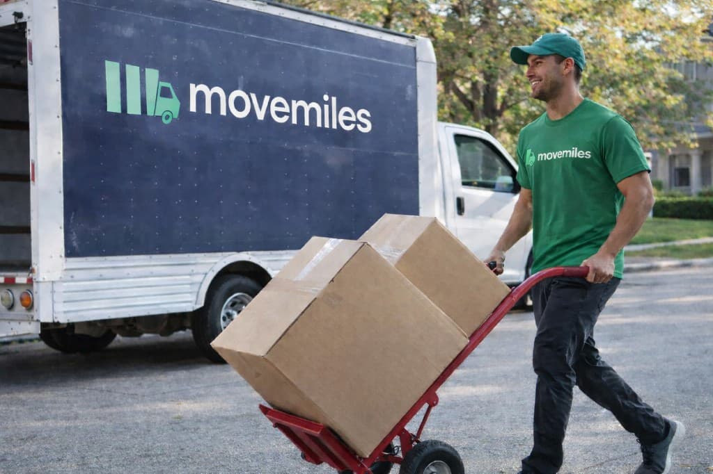 Movemiles mover with hand truck and moving boxes by a Movemiles truck